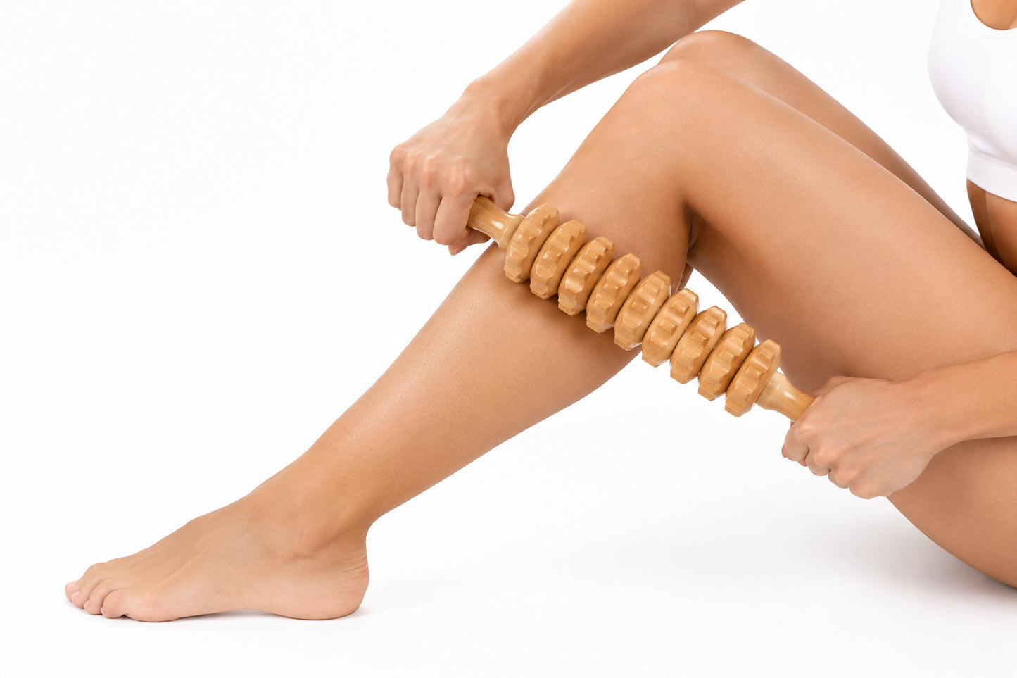 Person som masserar benet med en manuell massagerulle